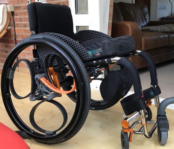 Wheelchair wheels with black & orange carbon springs for suspension from Loopwheels